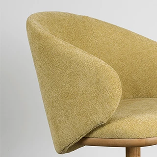 Vista de detalhe lateral da cadeira Angelina mostrando o revestimento de espumas estofadas e os encostos laterais