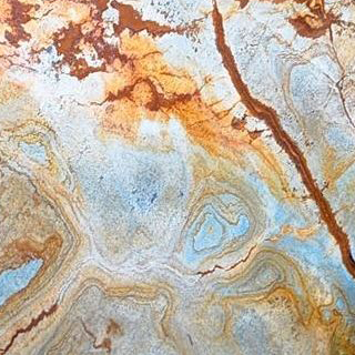 Foco em detalhe da mesa de apoio Ronnie com estrutura de bronze polido e tampo de mármore Blue Mare