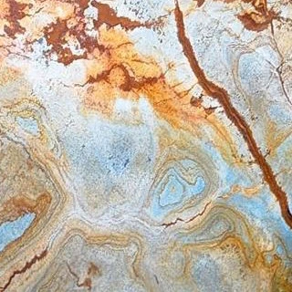 Foco em detalhe da mesa de apoio Ronnie com estrutura de bronze polido e tampo de mármore Blue Mare