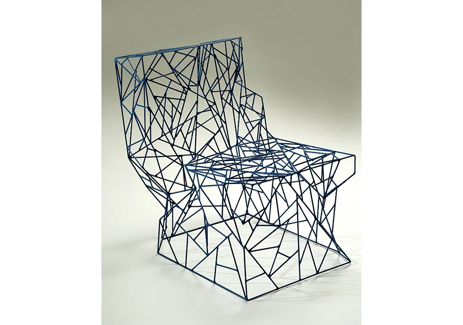 Close-up dos detalhes da cadeira, mostrando o intrincado trabalho das hastes de aço.