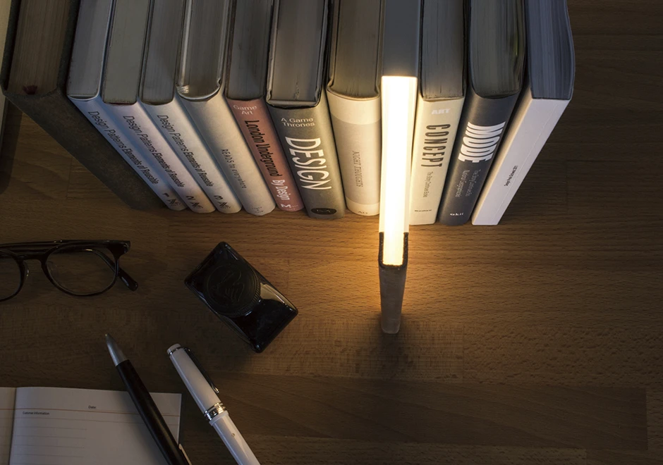 Vista detalhada da luminária de mesa Night Book em uso, destacando seu design único e elegante