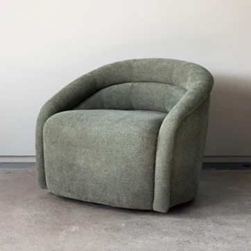 Vista lateral da poltrona Gomo em fundo branco, evidenciando os pés de madeira que podem ser fixos ou giratórios.