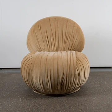 Vista frontal da poltrona Bio em fundo branco, destacando o estofado revestido em tecido franzido.