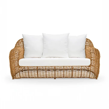 Sofá de três lugares de tecido branco, almofadas brancas e estrutura em fibra sintética trançada. Sofá de frente e em fundo branco.