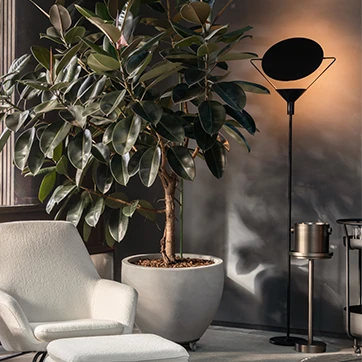 Luminária de chão 4419 da Dominici em um ambiente decorado, com destaque para sua forma elegante e disco rotacional, ao lado de uma poltrona e planta.