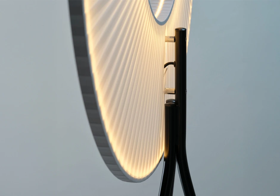 Vista lateral da luminária de chão Iris da DCW Éditions, destacando a iluminação circular e os detalhes do suporte