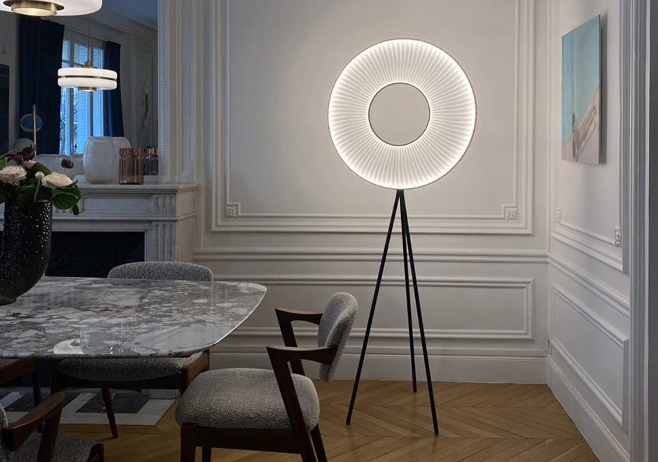 Luminária de chão Iris da DCW Éditions iluminando uma sala de jantar elegante com design contemporâneo e sofisticado.
