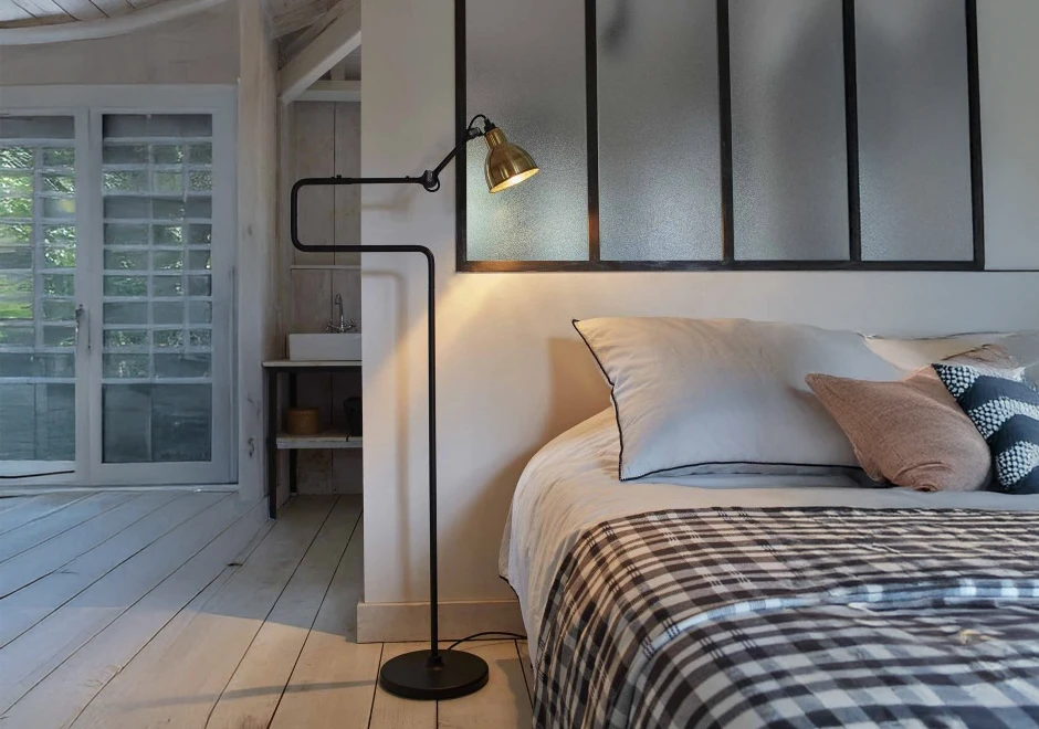 Luminária de chão Gras N°411 da DCW Éditions, em quarto com estilo clean e iluminação aconchegante.