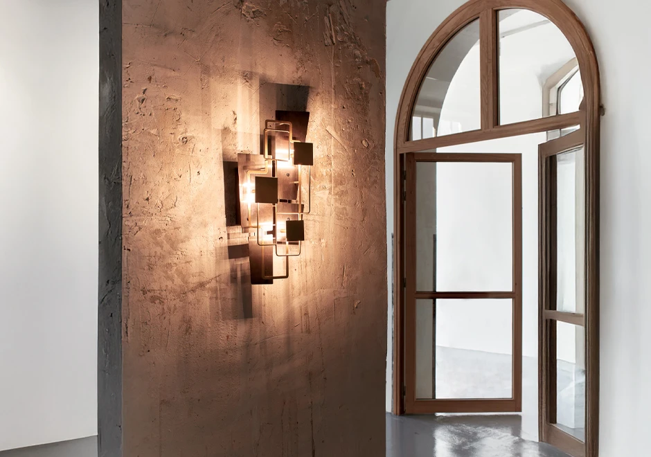 Foto da luminária de parede Map 2 iluminada, instalada em ambiente com design moderno e minimalista.