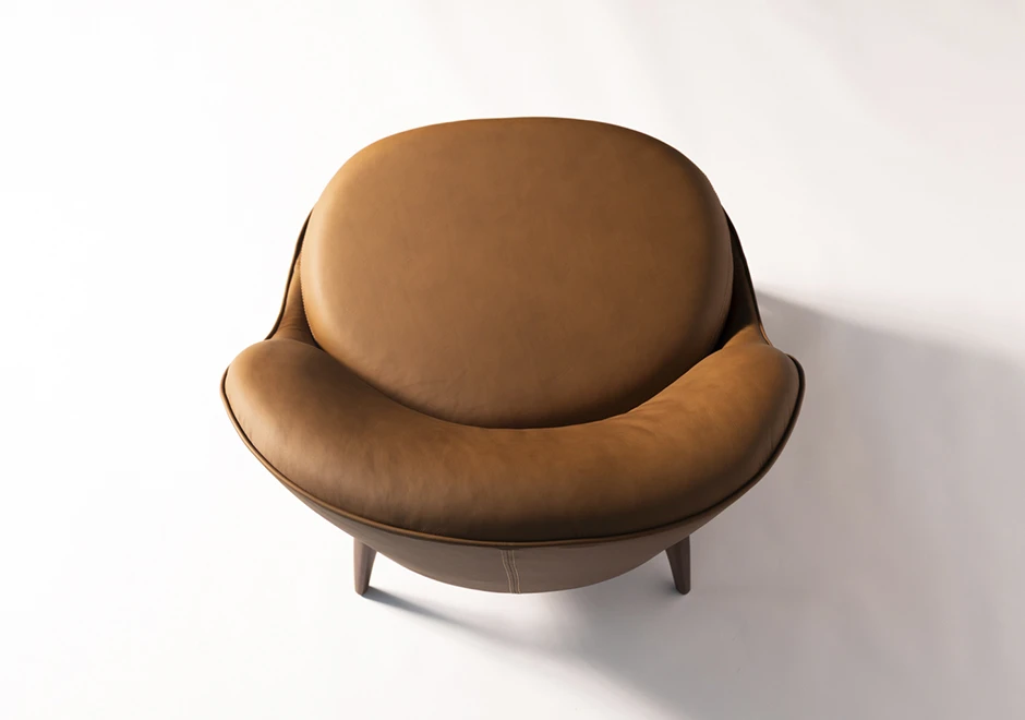 Vista superior da Poltrona Bromélia, destacando o assento amplo e encosto curvo estofado em couro caramelo, proporcionando conforto e sofisticação.