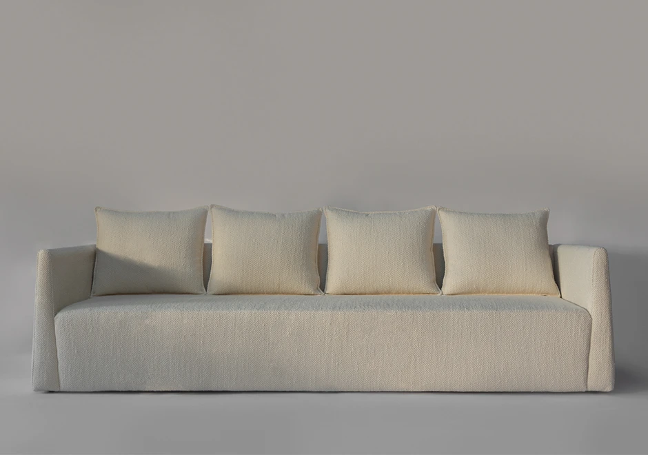 Sofá Pedro com design minimalista, estofado em tecido claro e almofadas soltas para conforto e elegância.