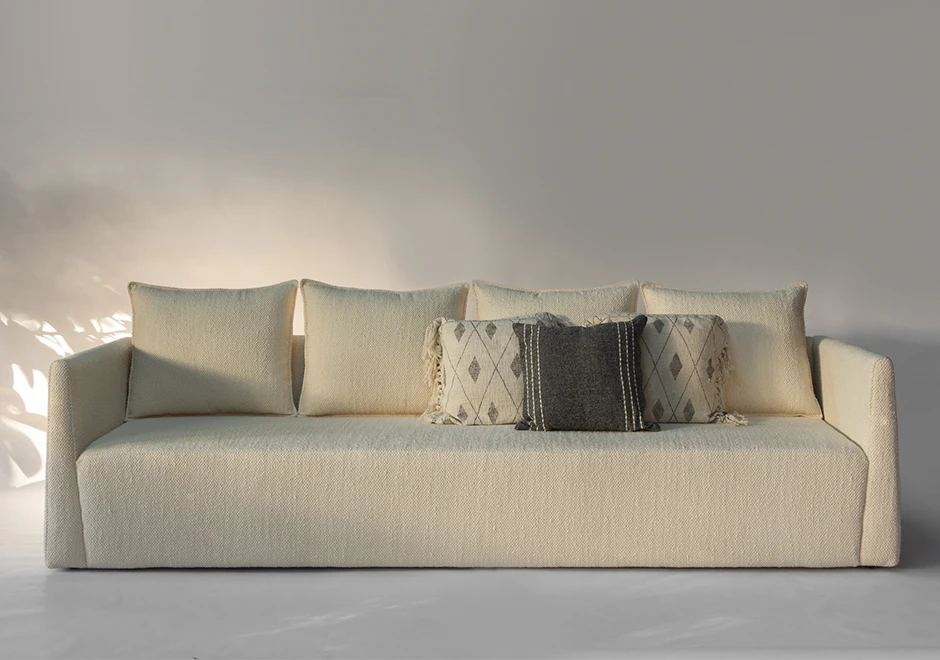 Sofá Pedro com almofadas decorativas em tons neutros, combinando conforto e sofisticação no design minimalista.