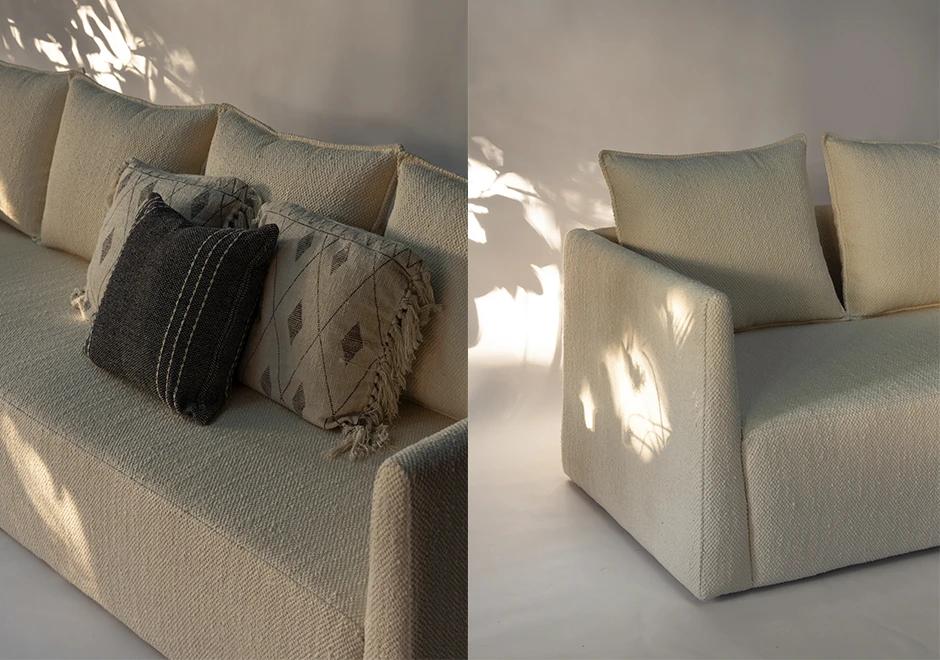 Detalhe do sofá Pedro, evidenciando textura sofisticada do tecido e almofadas decorativas em tons neutros, com iluminação natural realçando o design elegante.