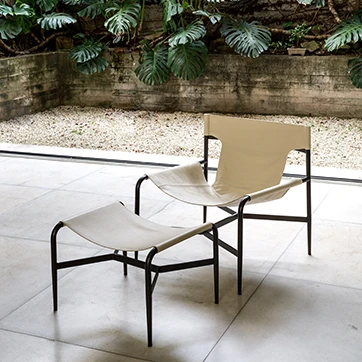 Sala com poltrona e Pufe Bruta estofada em couro off white.