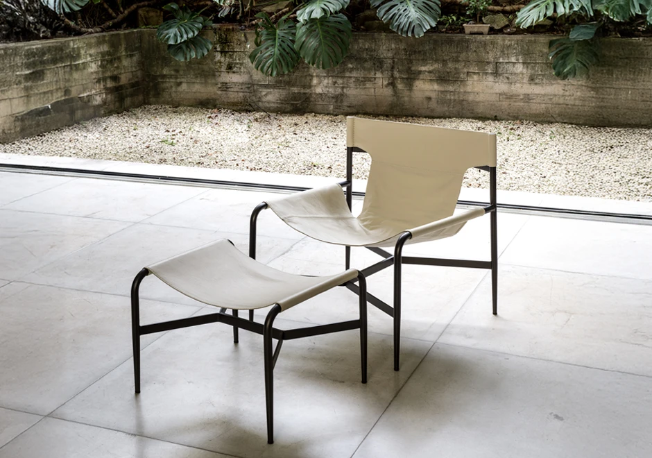 Sala com poltrona e Pufe Bruta estofada em couro off white.