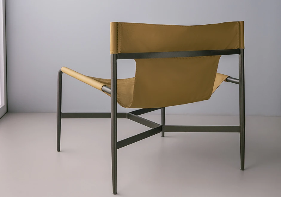 Vista lateral de trás da poltrona Bruta estofada em couro.