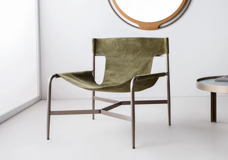 Sala com poltrona Bruta estofada em tecido verde.