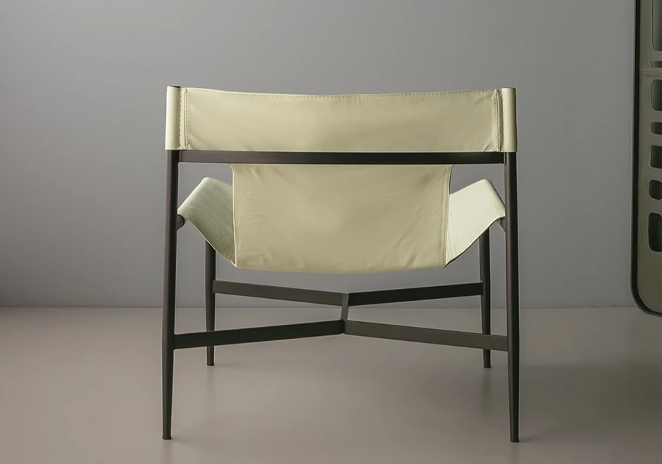 Vista de trás da poltrona Bruta estofada em couro off white.