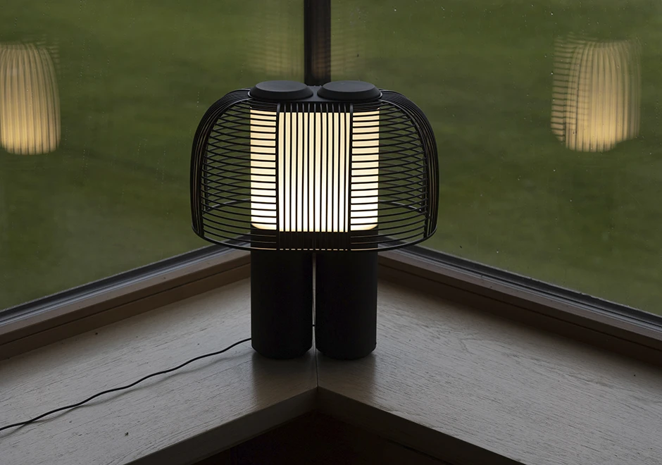 Luminária de mesa Yasuke acesa, na cor preta, acesa.