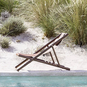 Vista lateral da cadeira Clever Foldable da marca Varaschin, na praia.