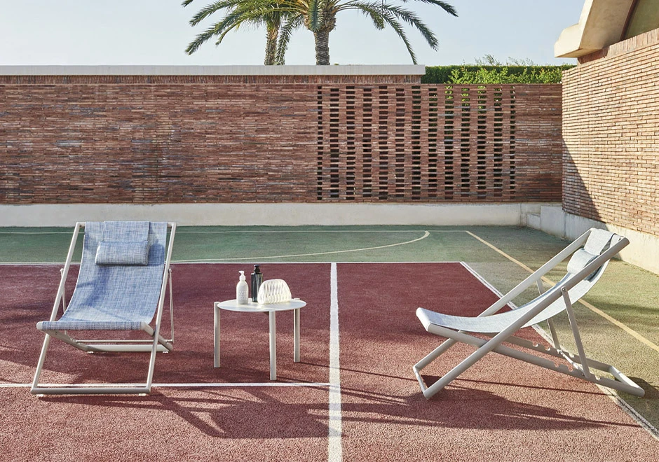 Cadeira Clever Foldable da marca Varaschin, na quadra de tenis.