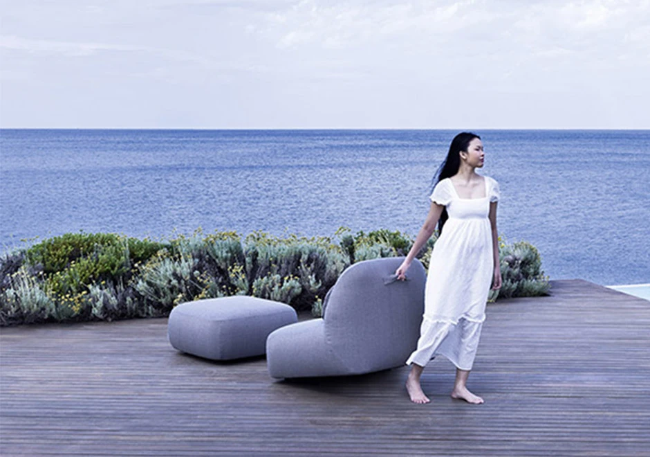 Poltrona e pufe Reuse da marca Varaschin em ambiente externo.